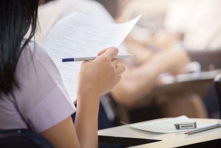 Girl looking at exam paper in exam hall