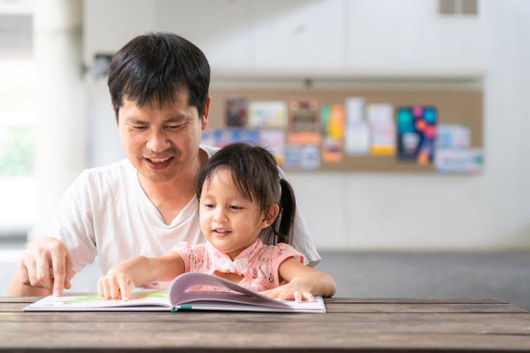 A father and daughter with book.