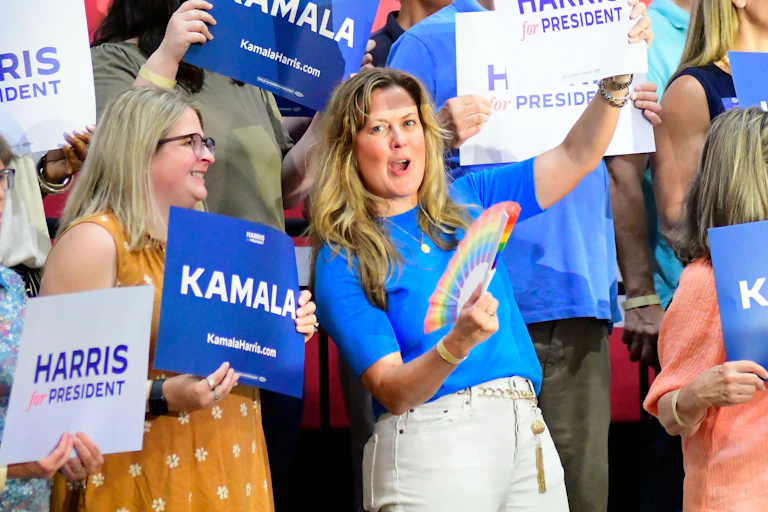 Apoiadores de Kamala Harris com pôsteres.