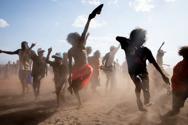 A group of Aboriginal men and boys perform in the outback
