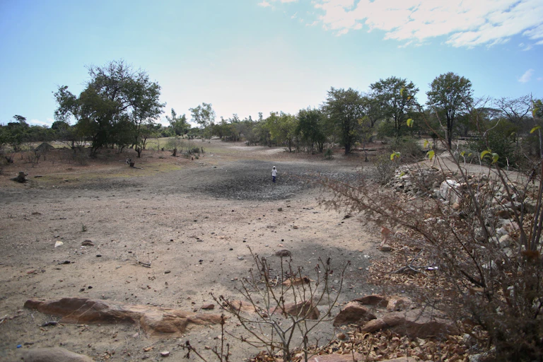 A big dusty area that shows no signs of formerly being a water filled dam