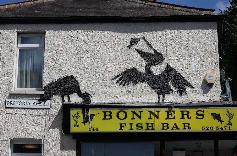 Pelicans stencilled above a fish bar.