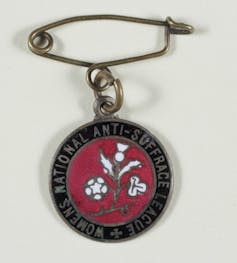 A round badge with a thistle emblem, featuring the words 'Women's National Anti-suffrage League'
