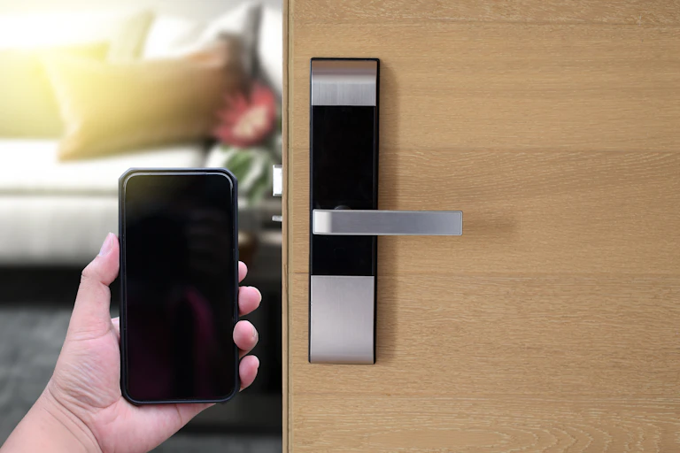 Une personne ouvre la porte d'une chambre d'hôtel avec son smartphone