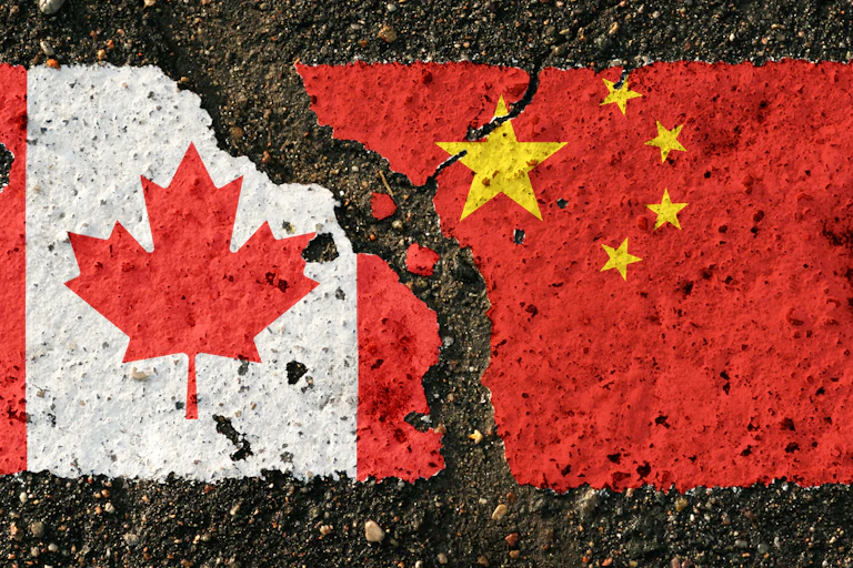 A rendering of a Canadian and Chinese flag on asphalt separated by a large crack.