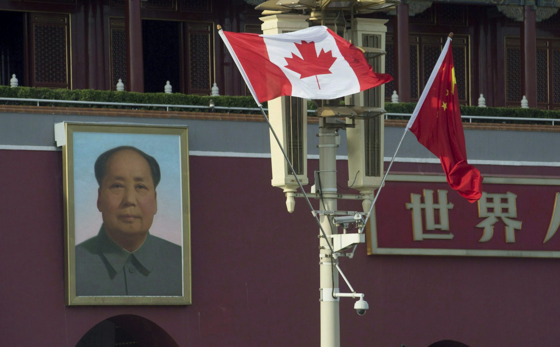 A Canadian flies next to a portrait of Chairman Mao.