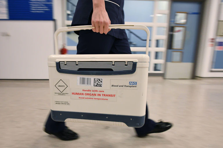 A person carrying a box containing a human organ for a transplant.