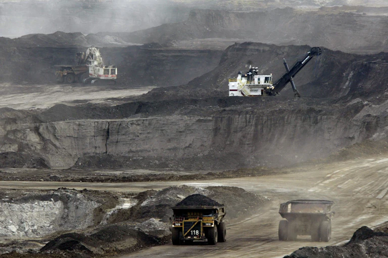Trucks drive about an openpit mine.