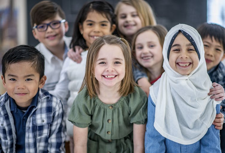 Eight students from diverse backgrounds smile.