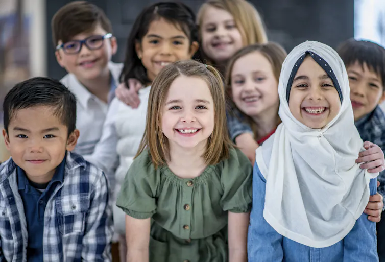 Eight students from diverse backgrounds smile.