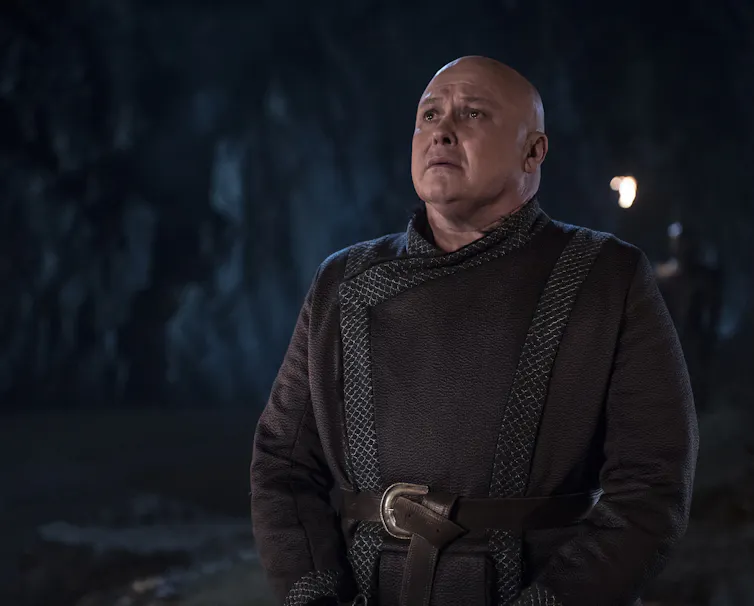The character of Varys in Game of Thrones looks up at a ceiling.