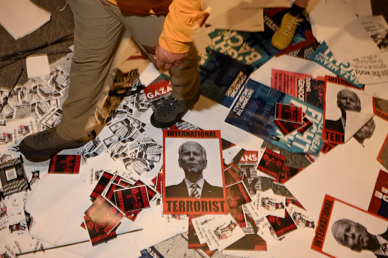 People's feet walking across pro-Palestinian protest posters.