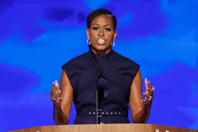 Michelle Obama standing at a podium, speaking.
