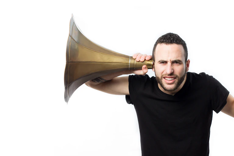 Un homme porte à son oreille un énorme sonotone.