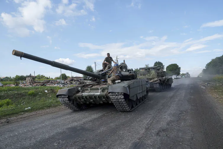 Vue d’un soldat debout sur un tank, sur une route