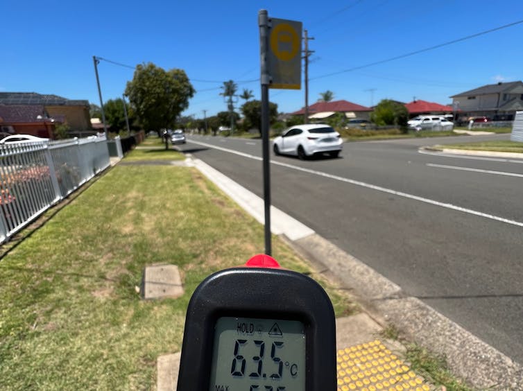A temperature reading shows 63.5 degrees at a bus stop without any shelter