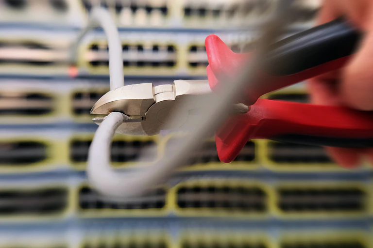 Photo of pliers disconnecting a wire