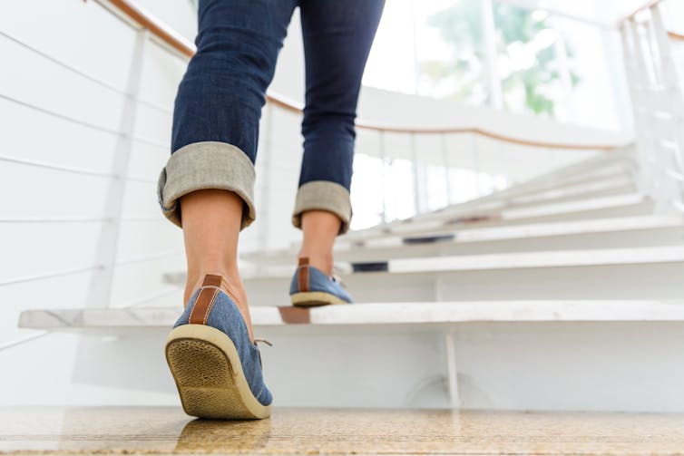 A woman's legs climbing a staircase.