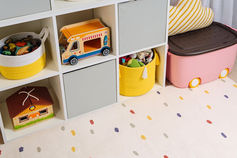A bookshelf with neatly arranged toys and boxes.