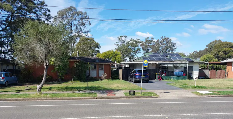 A milk crate has been placed next to a bus stop with no shelter or seating