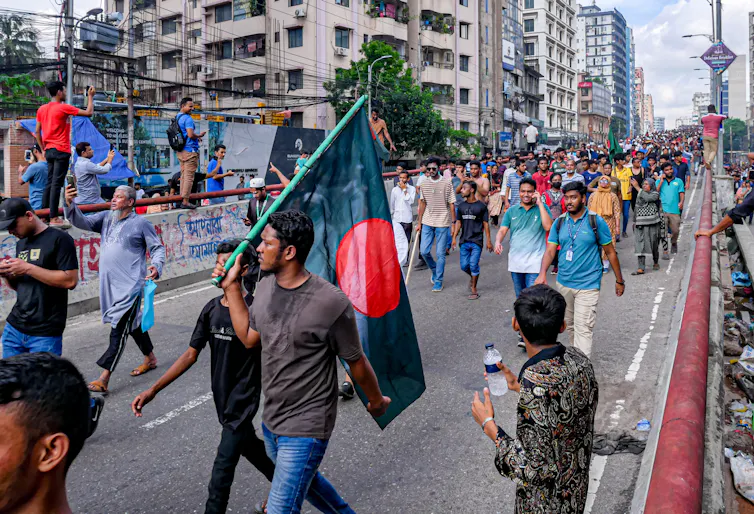 Bangladeshi protestors marching down a road.
