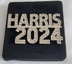 A rhinestone-encrusted pin reading 'Harris 2024.'