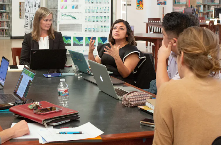 Teachers at a table in discussion.