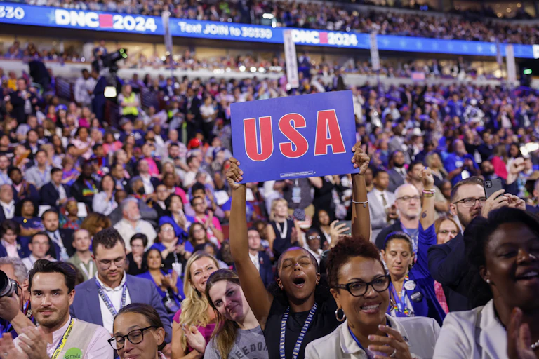 An audience member holds up a sign saying USA at the Democratic National Convention in Chicago