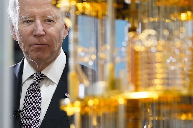 US President Joe Biden looks at the cooling apparatus of a quantum computer.