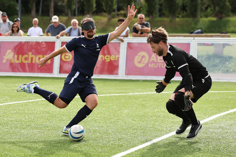 L'attaquant français Frédéric Villeroux tente de marquer contre le gardien français Alessandro Bartolomucci lors d'un entraînement public de l'équipe de France de football à 5 pour aveugles au stade Georges Carpentier à Lens, le 14 août 2024.
