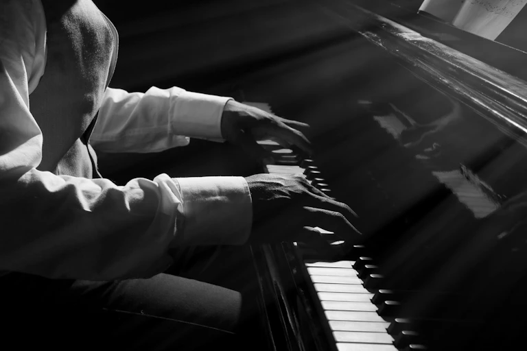 Una foto en blanco y negro de unas manos tocando el piano.