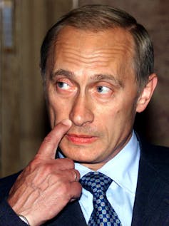 A man scratches his lip