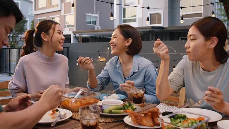 Friends eat dinner on a rooftop terrace