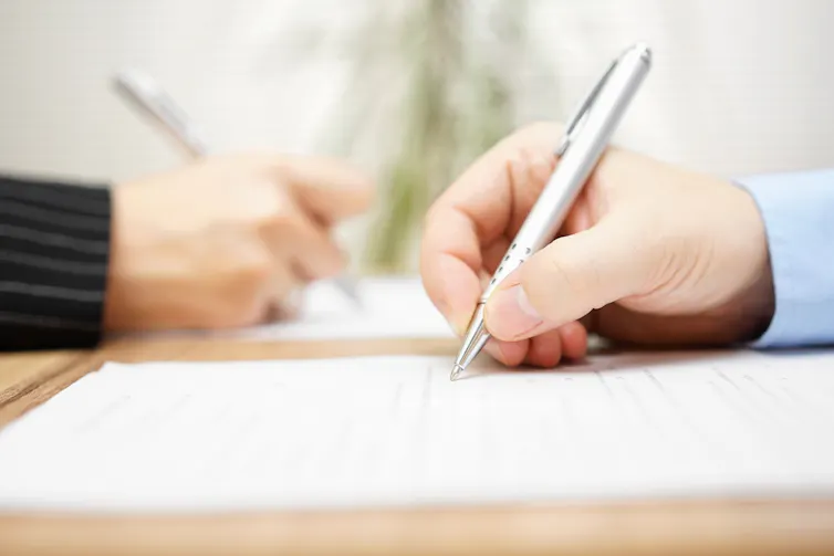 man and woman writing on document