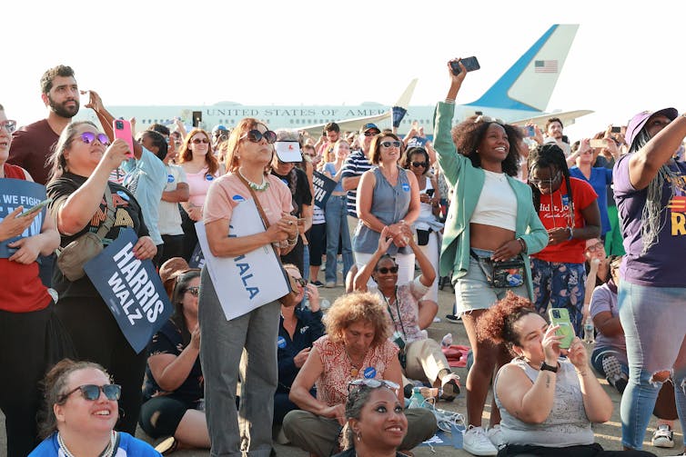 A crowd of people of different races attend a political rally for the Democratic presidential candidate Kamala Harris.
