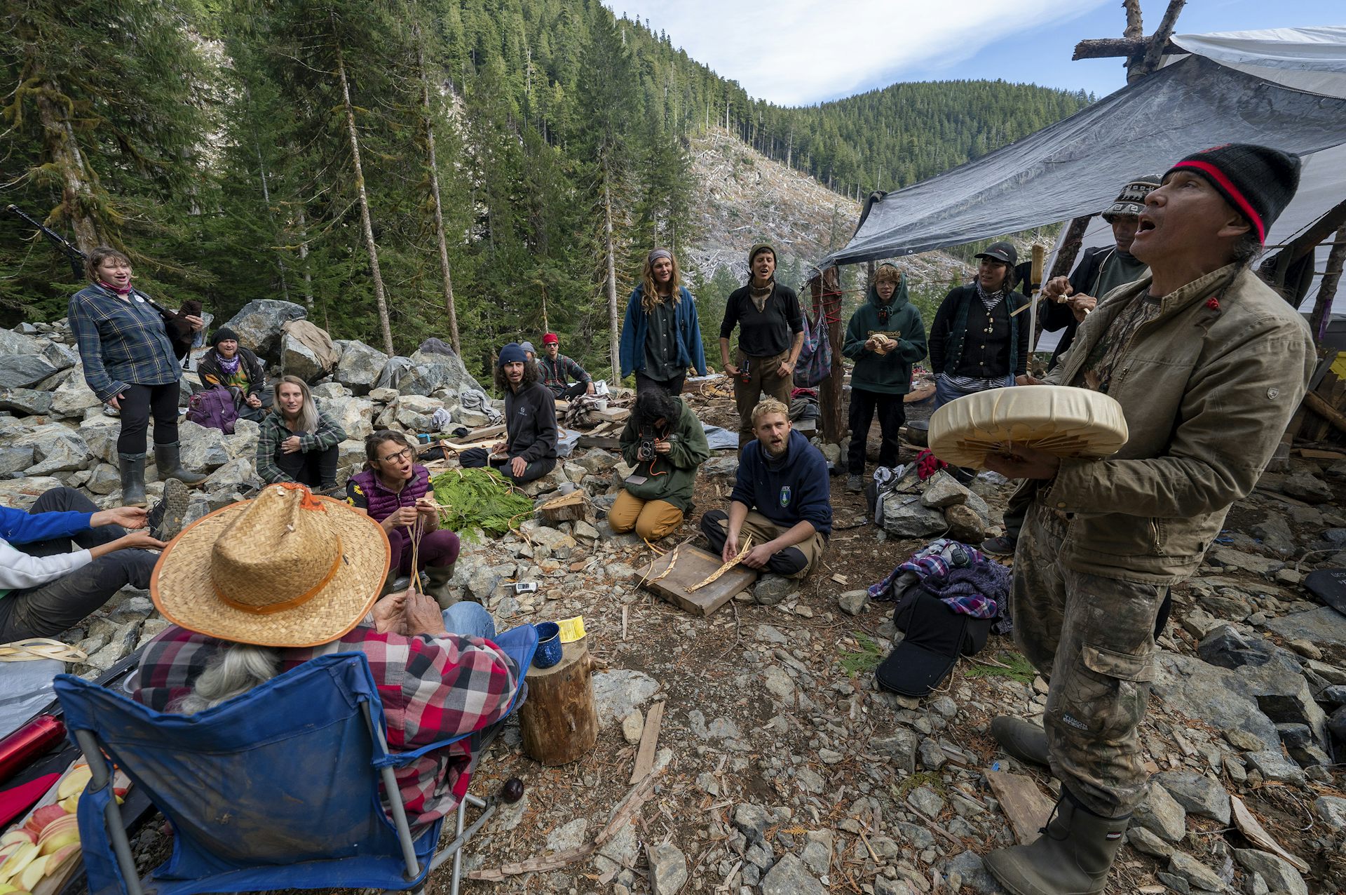 A group of people sit at a campsite