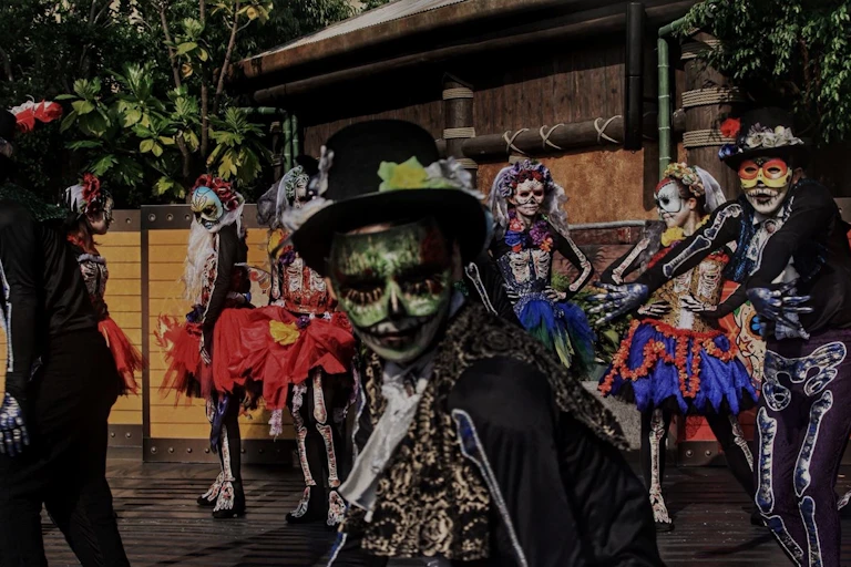 Gente bailando con disfraces del Día de los Muertos.s.