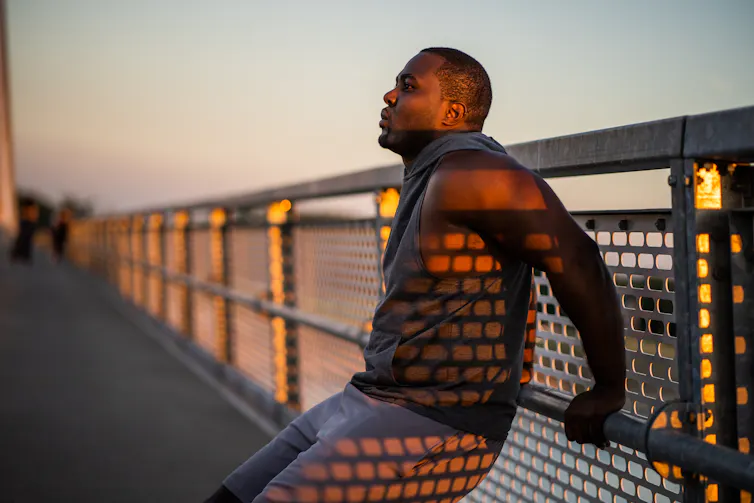 Man leans against a bridge rail