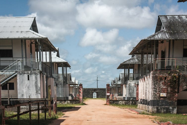 Decaying buildings in the main yard of a French overseas penal colony.