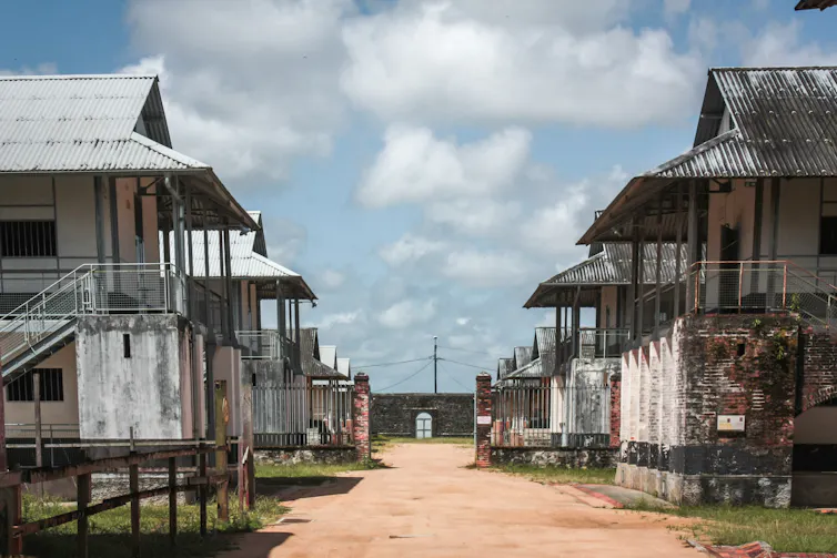 Decaying buildings in the main yard of a French overseas penal colony.