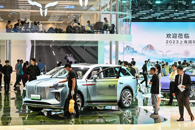 Un salon automobile. De nombreuses personnes regardent les voitures présentées.