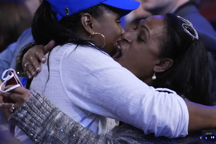 Two women hugging each other, happily.