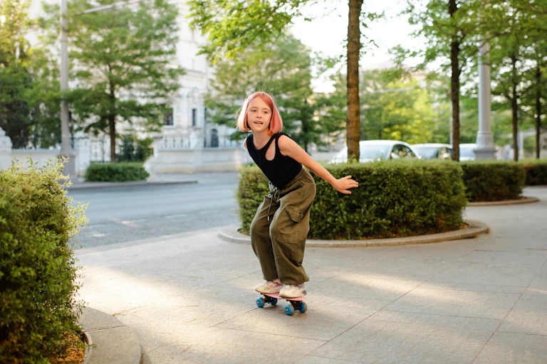 Child with pink hair and cargo pants skateboards