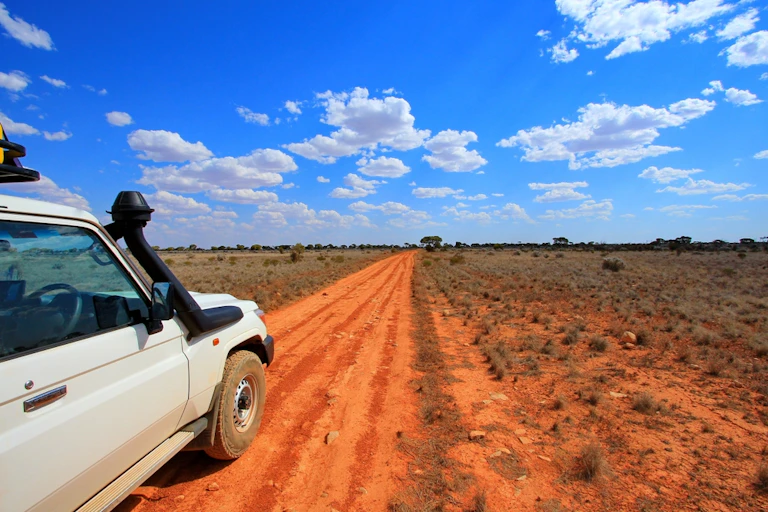 4WD car on red dirt road, outback Australia