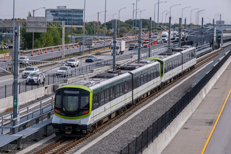 Light rail train skirts a highway