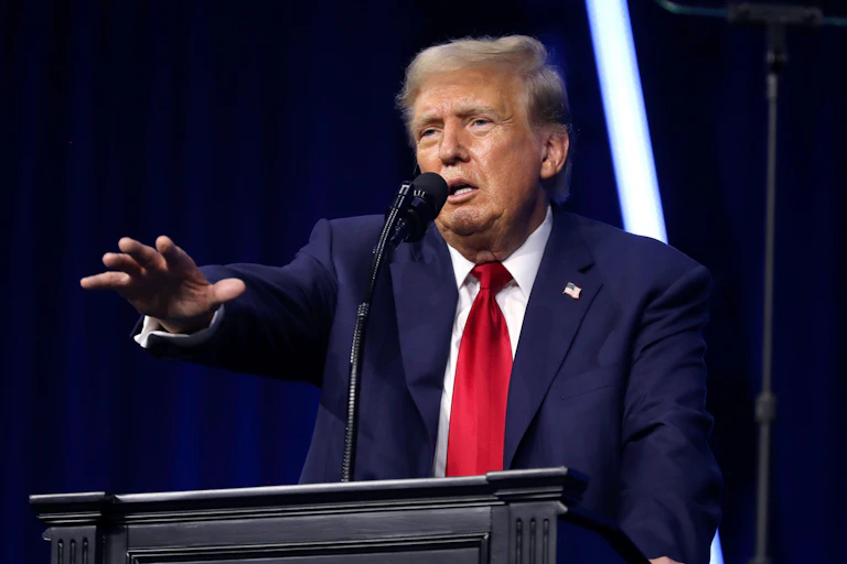 Donald Trump with his arm stretched out.