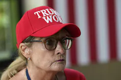 A woman wears a red ball cap that reads 'Trump Won.'