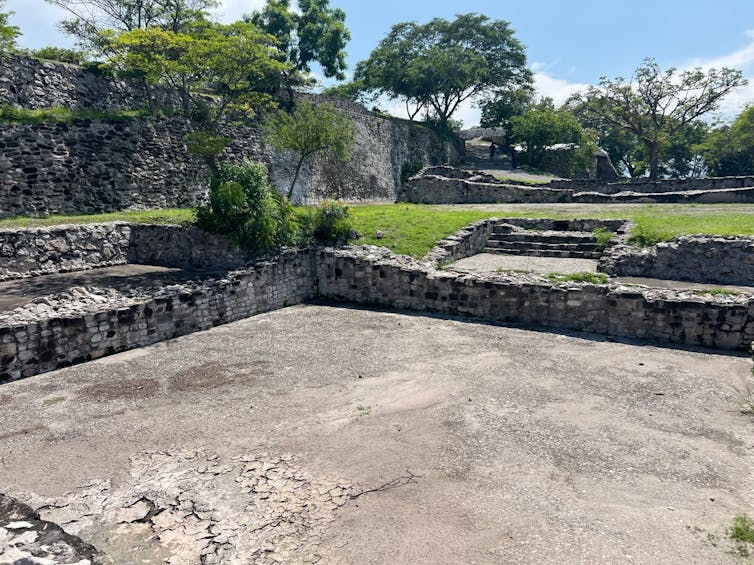 A large open area with a stone floor surrounded by stone walls.