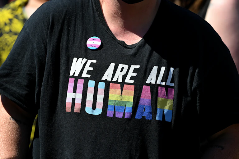A t-shirt that says we are all human in rainbow text