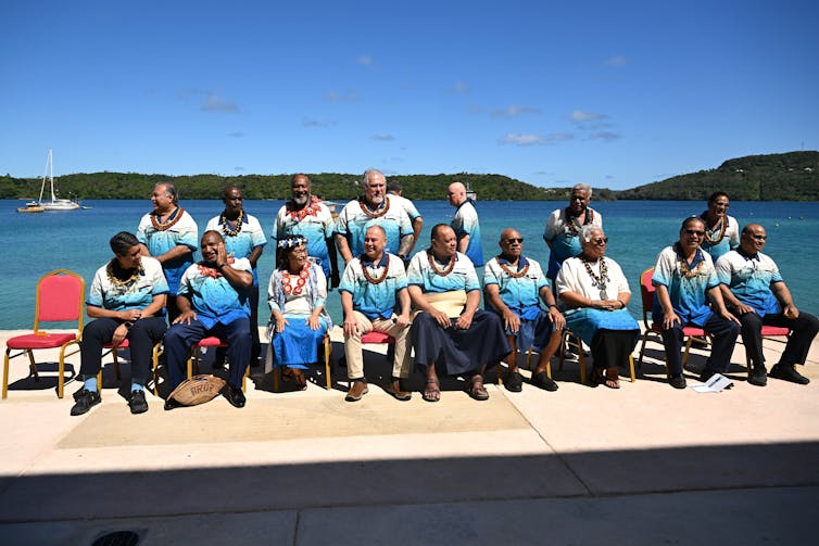 des gens assis pour une photo devant l'océan